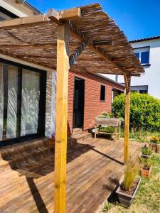 een houten pergola op een houten terras bij Notre petite maison in La Rochelle