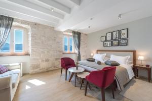 Schlafzimmer mit einem Bett, einem Tisch und Stühlen in der Unterkunft Heritage hotel Viganj in Orebić