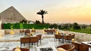 ein Restaurant mit Tischen und Stühlen vor der Pyramide in der Unterkunft Golf Pyramids View in Kairo