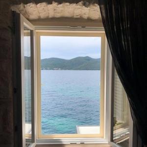 ein Fenster mit Blick auf das Wasser in der Unterkunft Heritage hotel Viganj in Orebić