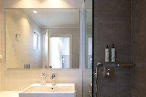 a bathroom with a sink and a shower with a mirror at High Beach Resort in Malia