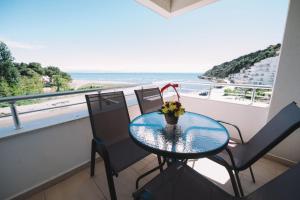 een tafel en stoelen op een balkon met uitzicht op de oceaan bij Apartments Art in Ulcinj