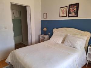 - une chambre avec un lit blanc et un mur bleu dans l'établissement Villa Margarida, à Viana do Castelo