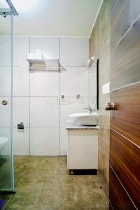 bagno bianco con lavandino e doccia di Elite Enclave - Mysore - 2BHK Luxury Serviced Apartments a Mysore