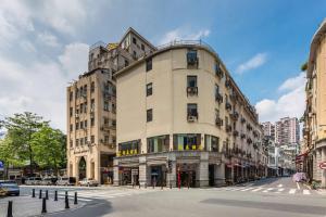 um grande edifício numa rua da cidade com uma faixa de pedestres em 锦泰酒店-广州市南方大厦国际电子城一德路地铁站店 em Guangzhou