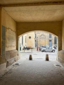 un arco en un edificio con coches en un estacionamiento en Le Roy Soleil, en Versalles