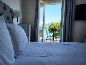 una camera con letto e vista su un balcone di Sempione Boutique Hotel a Stresa