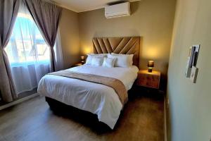 um quarto com uma cama grande e uma janela em Cozy 1-Bed Apartment in Gaborone em Gaborone