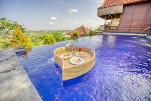 uma pequena mesa à beira de uma piscina em Sebuluh Sunset Hill em Nusa Penida