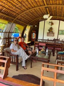 mężczyzna i kobieta siedzący w pokoju w obiekcie Thara's Houseboat w mieście Alappuzha