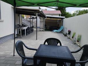 a patio with a table and chairs and an umbrella at Viola Apartmanház in Bogács