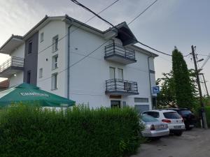 een wit gebouw met auto's ervoor geparkeerd bij Ambient Apartments in Struga