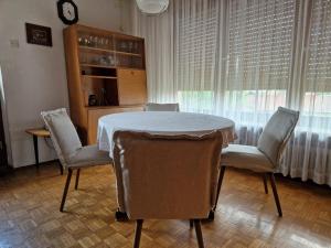 una sala da pranzo con tavolo, sedie e orologio di GreenFamilyAppartment near Ljubljana a Domžale