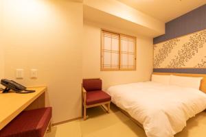 a bedroom with a bed and a desk and a phone at Onyado Nono Asakusa Natural Hot Spring in Tokyo