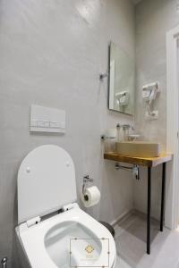 a bathroom with a white toilet and a sink at HM Boutique Hotel in Krujë