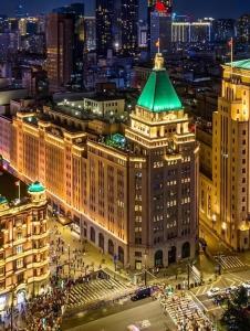 uma vista para um edifício com um telhado verde à noite em Fairmont Peace Hotel on the Bund em Xangai