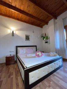 Un dormitorio con una gran cama blanca con flores. en Elsa's Villa, en Gjirokastra