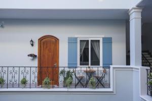 uma casa com uma varanda com uma porta e vasos de plantas em Serenity by the Sea em Mui Ne