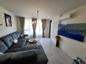 a living room with a large couch and a tv at Sea view luxury appartment in Varna City