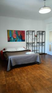 a bedroom with a bed with a painting on the wall at Rome Apartment D'Amata in Ciampino