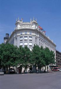 um grande edifício branco com árvores em frente em NH Madrid Nacional em Madrid