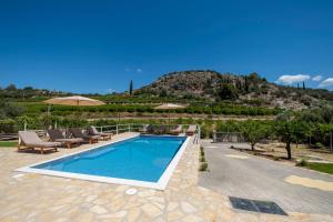 - une piscine avec des chaises et des parasols à côté d'une montagne dans l'établissement Tolo Villa Natura with Pool for 8 - private, luxury accommodation, à Tolón