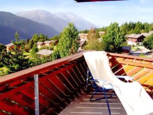 a balcony with a chair and a view of mountains at Cosy Apartment in Bellwald 68 m² Mountain View in Bellwald