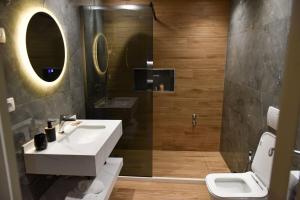 a bathroom with a sink and a toilet and a shower at Vila Noar in Vlorë