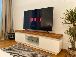 telewizor w białym centrum rozrywki w salonie w obiekcie Modern Zentral Parkplatz Terasse Netflix w mieście Straubing