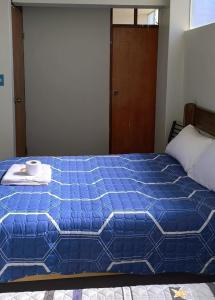 a blue bed with a plate and a cup on it at PEPE´S HOUSE in Puno