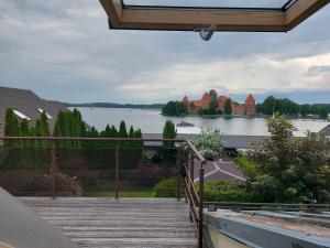 een balkon met uitzicht op een meer en een kasteel bij Villa55 in Trakai