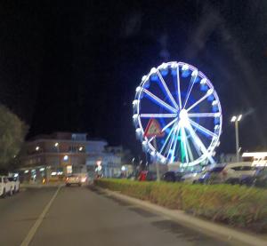 a ferris wheel in a city at night at Sweet Home FCO Airport Roma in Fiumicino