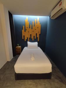 um quarto com uma cama branca e uma parede azul em Kingston Hotel 7, Johor Bharu em Johor Bahru