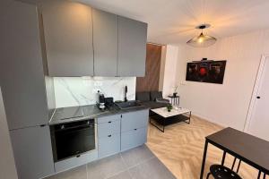 una cocina con armarios blancos y una mesa en una habitación en Superbe appartement neuf 2 pièces Vincennes pte de Paris, en Montreuil