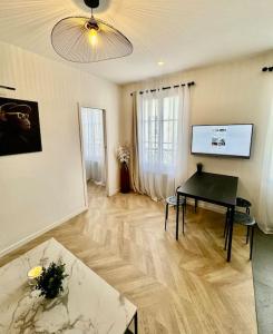 sala de estar con mesa y TV en Superbe appartement neuf 2 pièces Vincennes pte de Paris, en Montreuil