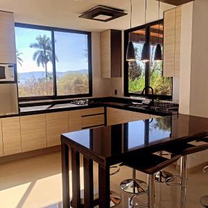 a kitchen with a large kitchen island and large windows at Villa Baruch in San Juan Cosalá