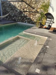 a swimming pool with a bird cage in front of a building at Villa Baruch in San Juan Cosalá