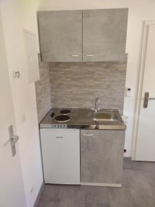 cocina pequeña con fregadero y fogones en apartment-bb, en Böblingen