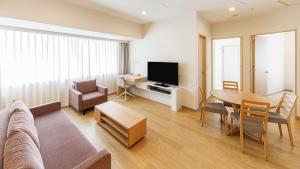 uma sala de estar com um sofá, uma mesa e uma televisão em Fraser Residence Nankai Osaka em Osaka