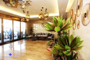 um lobby com um monte de plantas verdes em Lotus Blu Hotel em Legazpi