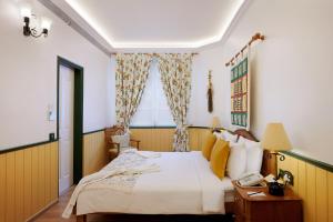 A bed or beds in a room at The Gordon House Hotel, Colaba