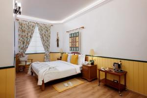 A bed or beds in a room at The Gordon House Hotel, Colaba