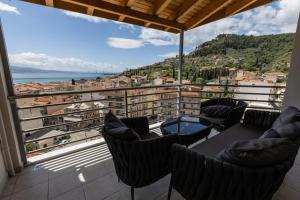 a balcony with chairs and a view of a city at ΑμφιΘΕΑ! στη ΝΑΥΠΑΚΤΟ ! in Nafpaktos