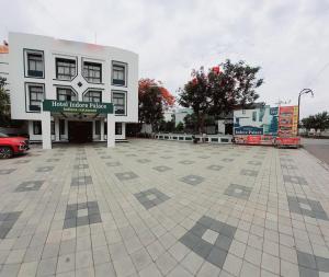 een groot wit gebouw met een bord ervoor bij Hotel Indore Palace - Guest Centric Hotel in Shirdi