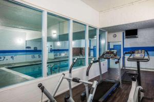 a gym with a swimming pool and three treadmills at Howard Johnson Hotel by Wyndham Victoria in Victoria