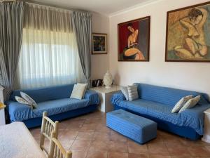 ein Wohnzimmer mit 2 blauen Sofas und einem Tisch in der Unterkunft Aqua Orbetello in Orbetello