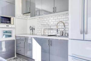 a kitchen with white cabinets and a sink at "Le Sérénity ", Appartement spacieux ,balcon, parking privé gratuit, proche CDG et Stade de France in Stains