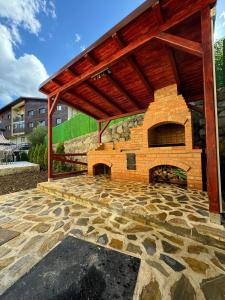 une terrasse en pierre avec une grande cheminée en briques dans l'établissement Ollie's Mountain Chalet, à Buşteni