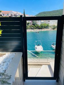 een balkon met uitzicht op een boot in het water bij Seasight in Neum