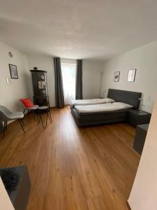 1 dormitorio con 1 cama y suelo de madera en B&B Berninapass, en Poschiavo